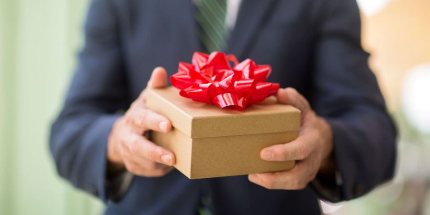 Businessman mit Geschenk in der Hand