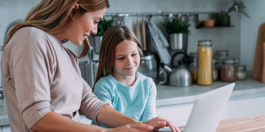 Mutter mit Tochter vor dem Laptop