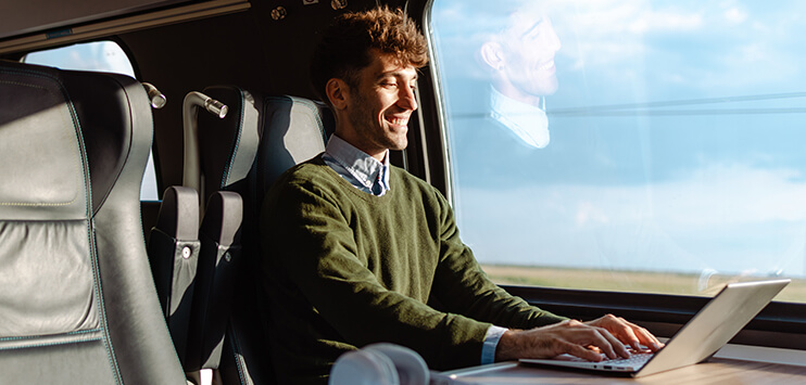 Geschäftsreisen und Reisekosten 2025 – Einfach abrechnen mit digitalen Lösungen Geschäftsreisender im Zug mit Laptop und Belegen bei der digitalen Reisekostenabrechnung